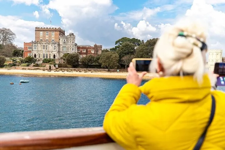 Frau fotografiert Brownsea Castle von einem Boot auf dem Wasser aus